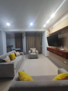a living room with couches and a flat screen tv at Soto Apartamentos in Chiclayo