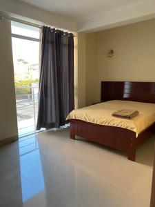 - une chambre avec un lit et une grande fenêtre dans l'établissement Soto Apartamentos, à Chiclayo