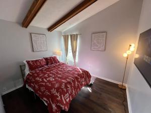 a bedroom with a red bed and a window at Cincy Short Stays : Cozy Ranch Retreat in Cincinnati