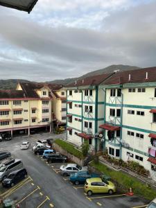 a parking lot with cars parked in front of buildings at D'Puncak Arabella Muslim Homestay in Cameron Highlands