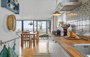 a kitchen with a sink and a table with chairs at Nice Home In Rude With Wifi in Rude