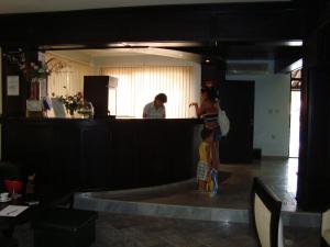 a woman and a child standing at a counter at Hotel Villa Ofir in Sandanski +125 photos