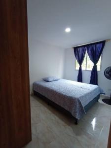 Schlafzimmer mit einem Bett und einem Fenster in der Unterkunft Agradable y Económico Apartamento in Santa Fe de Antioquia