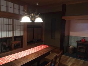 B&B Ladies Only Grape mama Peach room - Vacation STAY 11708 في Koshu: غرفة طعام مع طاولة طويلة وثريا