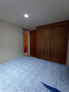 an empty bedroom with a bed and wooden cabinets at Agradable y Económico Apartamento in Santa Fe de Antioquia