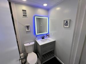 a white bathroom with a sink and a mirror at Cincy Short Stays : Cozy Ranch Retreat in Cincinnati