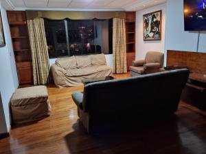 een woonkamer met een bank, een stoel en een tafel bij Advocatus’ Flat in Cuenca