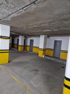 een lege parkeergarage met gele en witte muren bij Advocatus’ Flat in Cuenca