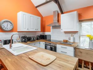 a kitchen with a sink and a clock on the wall at The Barn Annexe in St. Just