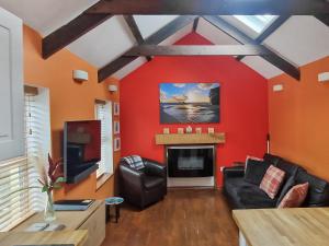 a living room with red walls and a fireplace at The Barn Annexe in St. Just
