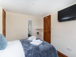 a bedroom with a bed with towels on it at The Barn Annexe in St. Just