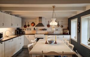 cocina con mesa, sillas y lámpara de araña en 3 Bedroom Cozy Home In Farsund en Farsund