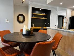 a dining room with a table and some chairs at Luxury marina view Apartment cairns in Trinity Beach
