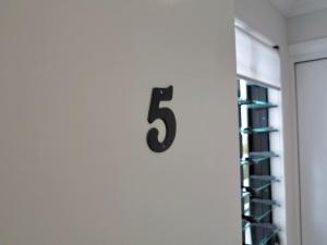 a number on a wall next to a rack of wine glasses at Bluewater Apartment in Trinity Beach