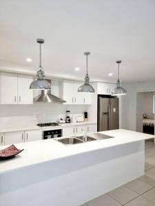 a white kitchen with white cabinets and a sink at 5-Bedroom House: Ensuite, Netflix, Prime Location in Waterford