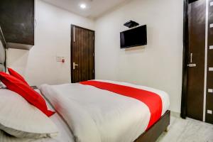 a bedroom with a bed and a tv on the wall at OYO Anshun Residency Near M2k Cinemas Rohini in New Delhi