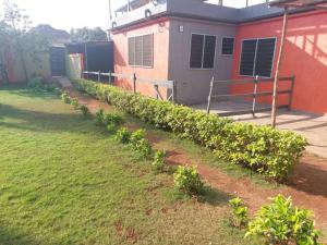 Une rangée de plantes dans une cour à côté d'une maison dans l'établissement Château angele w&b, à Lomé