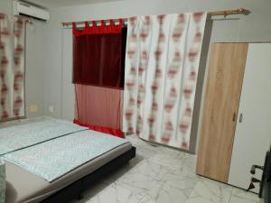 1 dormitorio con 1 cama y una ventana con cortinas en Château angele w&b, en Lomé