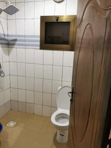 bagno con servizi igienici e porta in legno di Villa(Belle)près de Ouaga 2000. a Ouagadougou