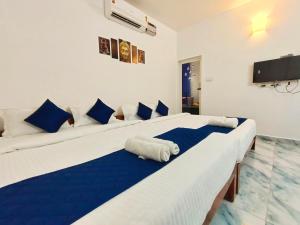 two beds in a room with blue and white at De luma Seaview in Pondicherry