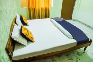 a bed with yellow and blue pillows on it at SPOT ON Nanki Palace in Ajmer