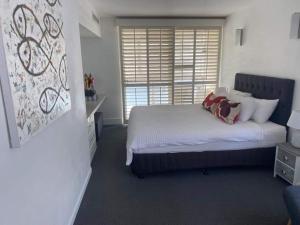 une chambre avec un lit avec des oreillers et une fenêtre dans l'établissement On Hastings Street, Noosa Heads Apartment Suite, à Noosa Heads 12 autres photos