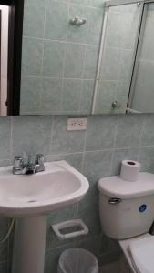ein Badezimmer mit einem Waschbecken, einem WC und einem Spiegel in der Unterkunft Aparta-estudio amoblado 202, 2p, wifi in Socorro