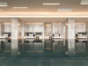 - un hall doté d'une piscine avec des chaises bleues et blanches dans l'établissement InterContinental Hotels Shenzhen WECC, an IHG Hotel, à Shenzhen