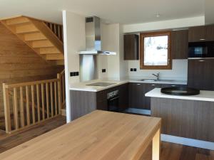eine Küche mit Holzschränken und einer Treppe in der Unterkunft Appartement Les Gets, 4 pièces, 6 personnes - FR-1-598-53 in Les Gets