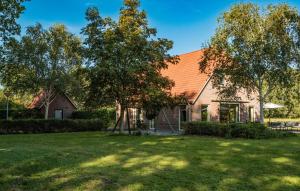 ein Haus mit Rasen und Bäumen davor in der Unterkunft 4 Bedroom Lovely Home In Havelte in Havelte