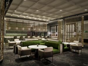 Shenzhen的住宿－深圳国际会展中心洲际酒店，餐厅设有绿色的沙发和桌椅