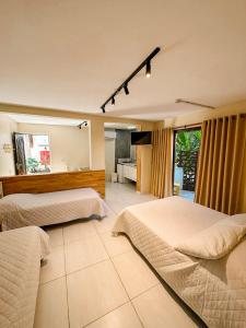 pokój hotelowy z 2 łóżkami i telewizorem w obiekcie Villa'l Mare Hotel w mieście Maresias