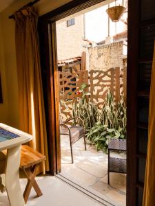 eine offene Tür zu einer Terrasse mit einem Tisch und Stühlen in der Unterkunft Villa'l Mare Hotel in Maresias