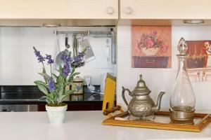 eine Küchentheke mit einem Wasserkocher und Blumen darauf in der Unterkunft Luzias Apartment in Funchal