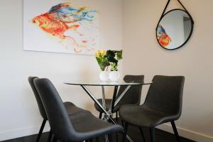 a dining room table with chairs and a mirror at Lovely Home in midtown Box Hill with two bedrooms in Box Hill