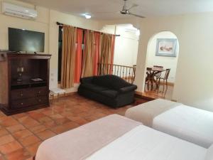 a hotel room with two beds and a couch at Apartotel Don Francisco in San José