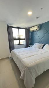 een groot wit bed in een kamer met een raam bij Luxurious apartment located in the heart of Panama in Panama-Stad