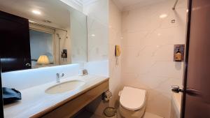 W łazience znajduje się umywalka, toaleta i lustro. w obiekcie T Hotel w mieście Taizhong