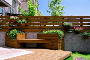 a wooden bench sitting on a wall with potted plants at Zhileju Homestay in Hualien City