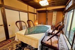 a dining room with a table and chairs and a window at Kigannoyado Aoshima Jizoan in Miyazaki
