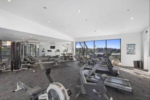 a gym with several cardio machines in a room at Convenient Modern 2Bed Apt Near Airport in Sydney