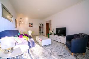 een woonkamer met een bank en een tv bij Cap les pins furnished flat in Antibes