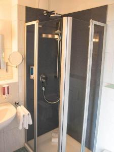 a shower with a glass door in a bathroom at Hotel Pommernland in Anklam