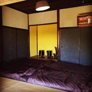 una camera da letto con un grande letto con lenzuola viola di 古民家一棟貸しNano Village Okayama a Kaga