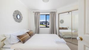 アンナ・ベイにあるAbsolute Oceanfront Portovenereの白いベッドルーム(ベッド2台、鏡付)
