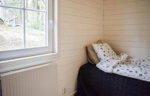 um pequeno quarto com uma cama e uma janela em Amazing Home In Sjbo With Wifi em Sjöbo
