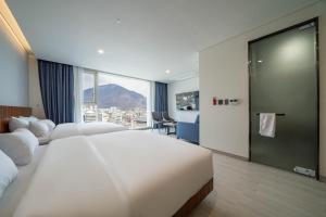 a hotel room with two beds and a large window at Hotel Orayeon in Yeongwol