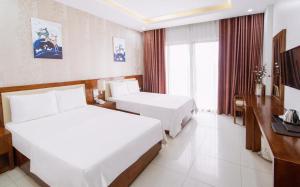 Habitación de hotel con 2 camas y TV en Sen Biển Hotel FLC Sầm Sơn en Sầm Sơn