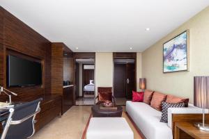 海口市にあるNewyantai Hotel Hainanのリビングルーム(白いソファ、テレビ付)