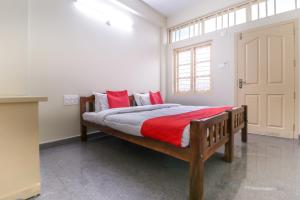 a bedroom with a wooden bed with red pillows at Appas Residency in Ambalavayal